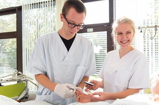 Pflegepersonal am Bett des Patienten