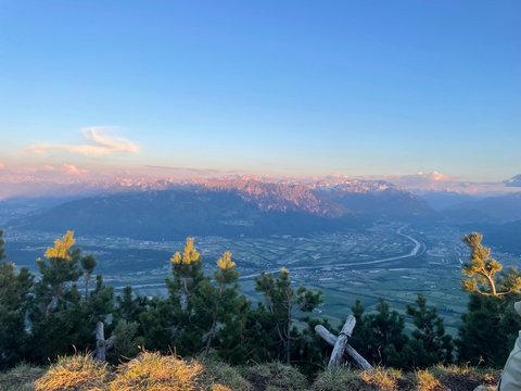 Das Bild zeigt den Sonnenaufgang über einer Stadt von einem hohen Aussichtspunkt aus.