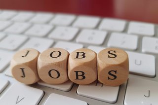 Vier Würfel mit Buchstaben, die den Schriftzug JOBS bilden