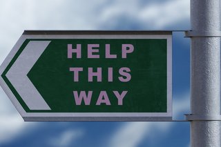 Mast mit Hinweisschild und Aufschrift "Help this Way"