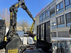 Blick auf die Seitefassade Hauptgebäude mit Baustelle und gelbem Lastkran links davor
