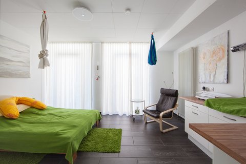 Heller Raum mit Bett und Schaukelstuhl