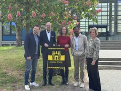 Prof. Dr. Michael Komorek (Vizepäsident), Prof. Dr. Sebastian Schröer-Werner (Präsident), Prof.in Dr. Natascha Naujok (Studiengang Kindheitspädagogik), Gideon Boateng (incoming student) und Tanja Reith (Referentin für Internationales) nach der Übergabe des Wandteppichs vor der EHB. 