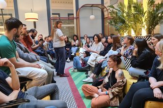 Große Gruppe von jungen Menschen sitzt sich gegenüber