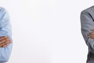 Zwei angeschnittene Personen (nur Oberkörper ohne Gesicht) stehen in großem Abstand nebeneinander