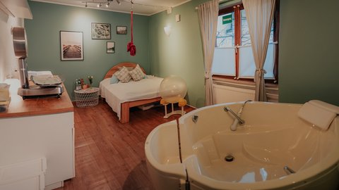 gemütliches Zimmer mit Bett und Badewanne