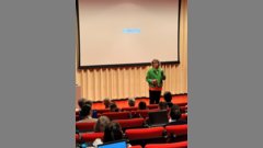 Person bei einem Vortrag vor Publikum