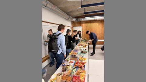 Das Bild zeigt einen langen Tisch auf dem ein großes Buffet vorbereitet ist.